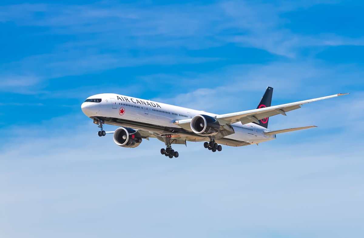 Air Canada airplane approaching for landing against a clear blue sky